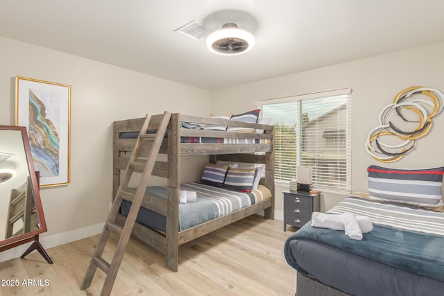 bedroom with baseboards, visible vents, and light wood-type flooring