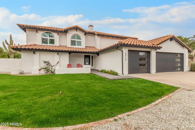 mediterranean / spanish home with a garage, a front yard, stucco siding, a chimney, and concrete driveway