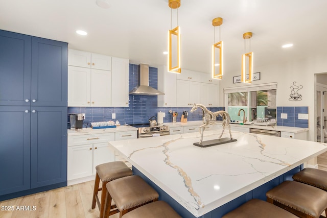 kitchen featuring wall chimney range hood, light stone counters, recessed lighting, a kitchen bar, and backsplash
