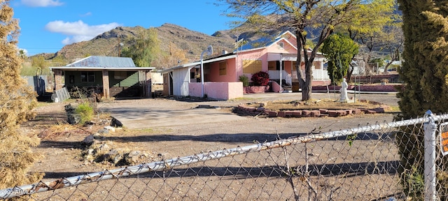 view of front of home with a fenced front yard, driveway, and a mountain view