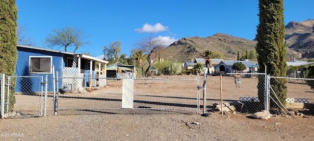 view of yard featuring a gate, fence, and a mountain view