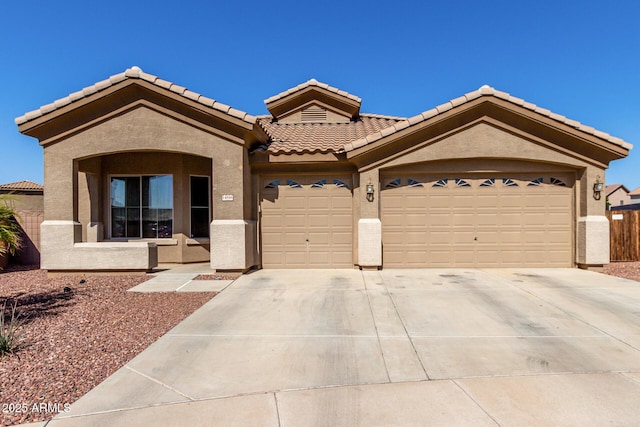 view of front of home with stucco siding, concrete driveway, an attached garage, and a tiled roof