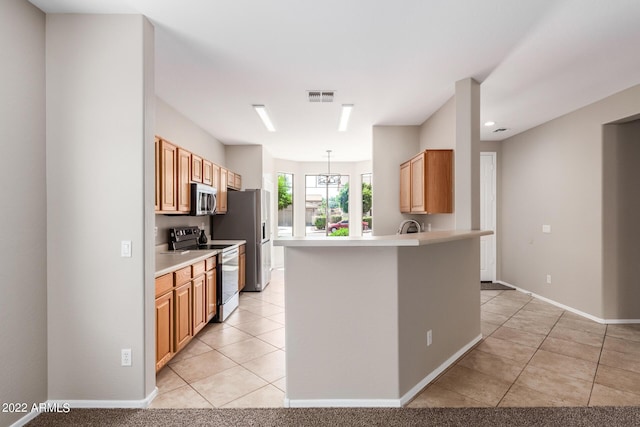 kitchen with visible vents, light countertops, appliances with stainless steel finishes, light tile patterned flooring, and a peninsula