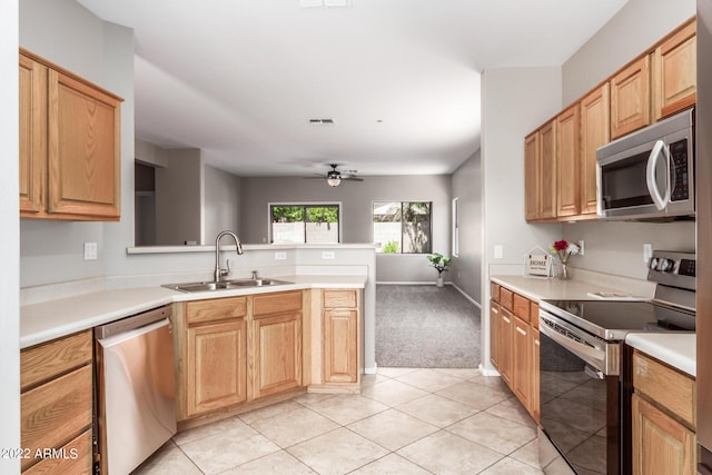 kitchen with visible vents, a ceiling fan, appliances with stainless steel finishes, light countertops, and a sink