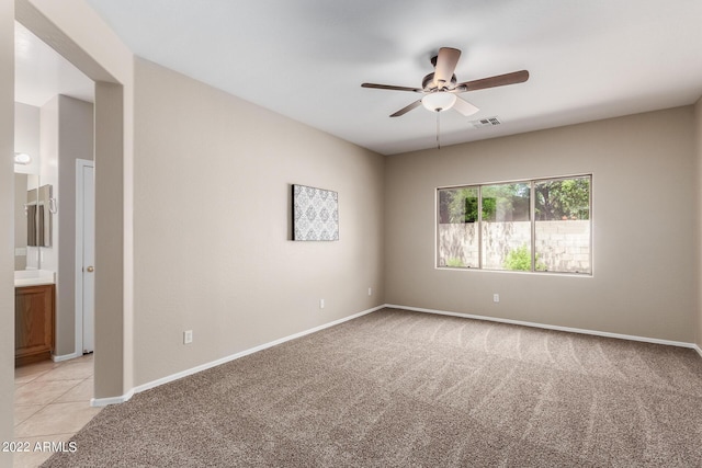 unfurnished room with baseboards, a ceiling fan, visible vents, and light colored carpet