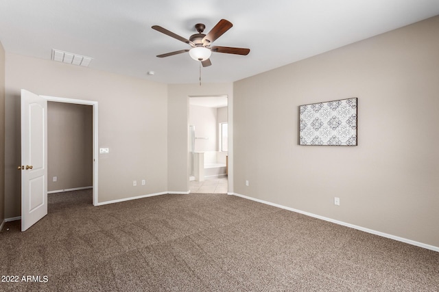 unfurnished bedroom with carpet floors, visible vents, a ceiling fan, ensuite bath, and baseboards