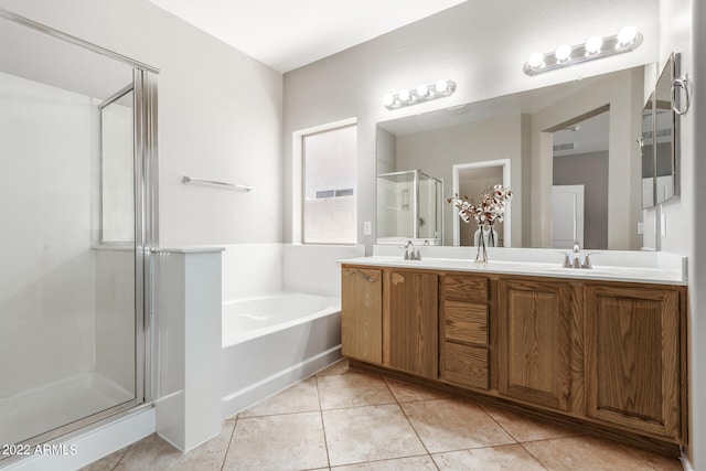 bathroom with double vanity, a stall shower, tile patterned flooring, and a bath