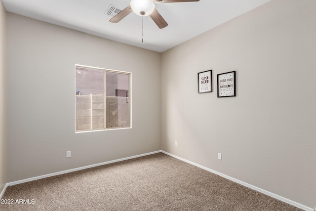 carpeted empty room with ceiling fan, visible vents, and baseboards