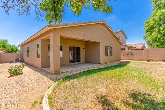 rear view of property featuring a yard, stucco siding, a patio area, central AC, and a fenced backyard