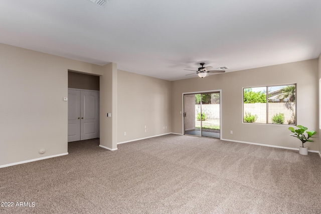 spare room with a ceiling fan, baseboards, and carpet flooring