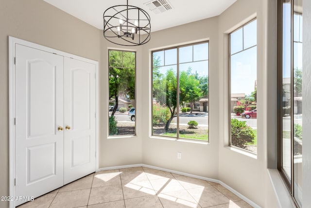 interior space featuring a notable chandelier, light tile patterned floors, visible vents, and a healthy amount of sunlight