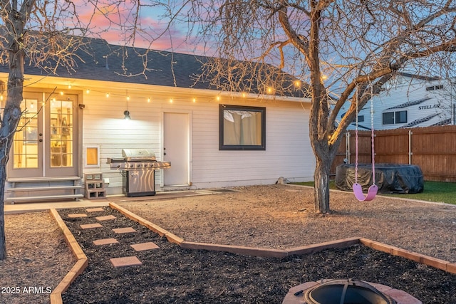 view of front of house with roof with shingles, fence, and entry steps