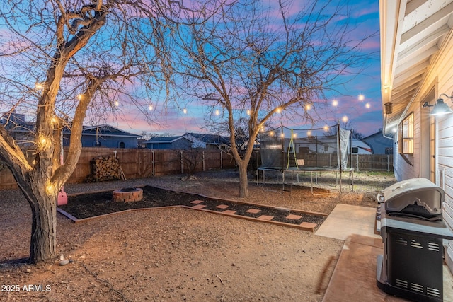 view of yard featuring a trampoline and a fenced backyard