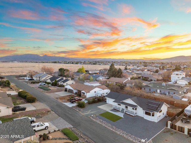 aerial view at dusk featuring a residential view and a mountain view