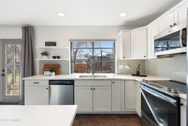 kitchen featuring a sink, white cabinetry, tasteful backsplash, and appliances with stainless steel finishes