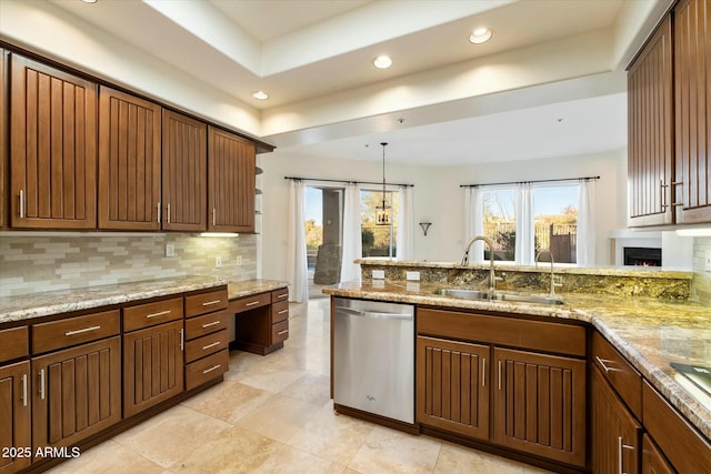 kitchen with dishwasher, pendant lighting, light stone counters, sink, and backsplash