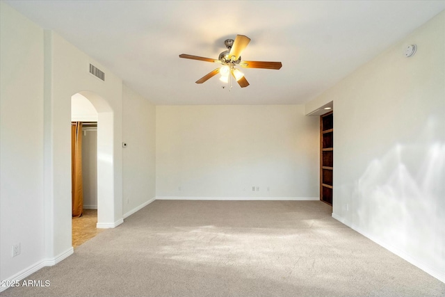 spare room with ceiling fan and light colored carpet