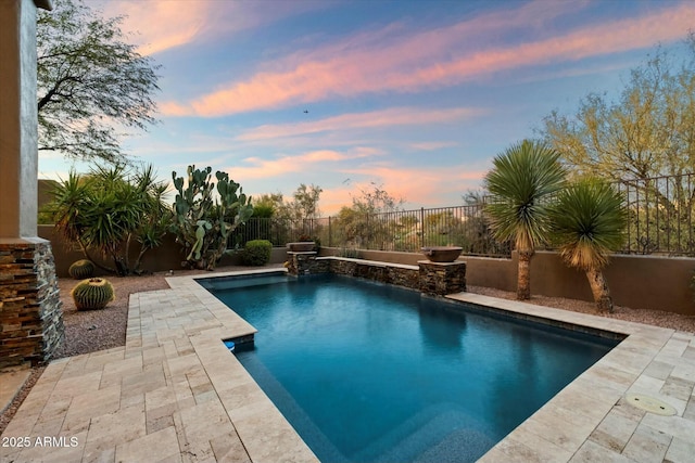 pool at dusk with a patio area