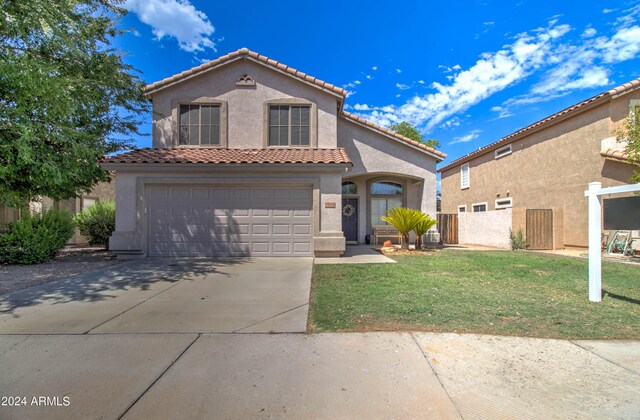 mediterranean / spanish-style house with a garage and a front yard