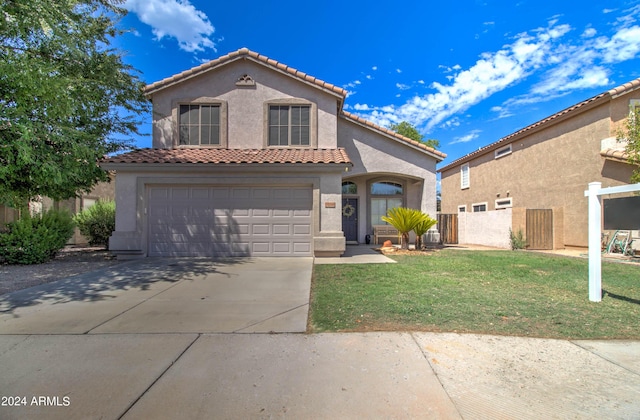 mediterranean / spanish-style house featuring stucco siding, concrete driveway, an attached garage, fence, and a front lawn