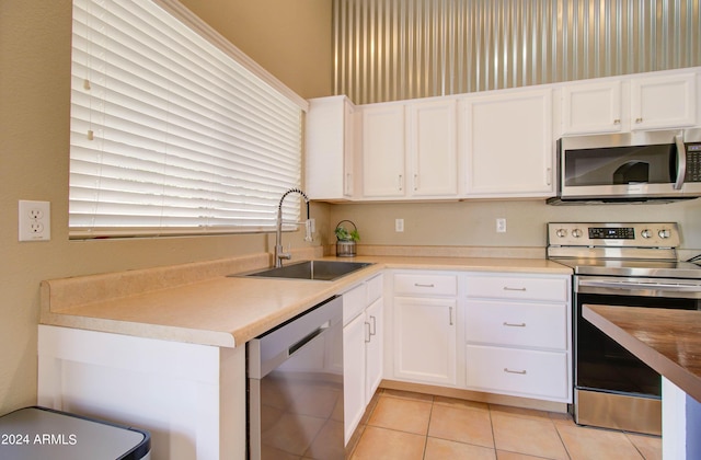 kitchen featuring white cabinetry, appliances with stainless steel finishes, light countertops, and a sink