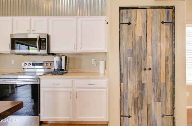 kitchen with light countertops, appliances with stainless steel finishes, and white cabinets