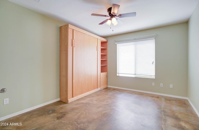 unfurnished bedroom featuring concrete flooring, baseboards, and a ceiling fan