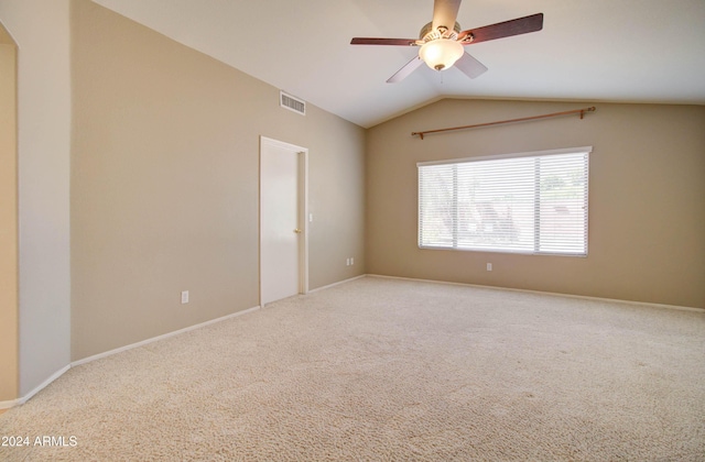 unfurnished room featuring lofted ceiling, carpet floors, visible vents, and a ceiling fan