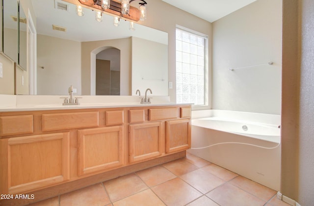 full bath with double vanity, visible vents, a garden tub, and tile patterned floors