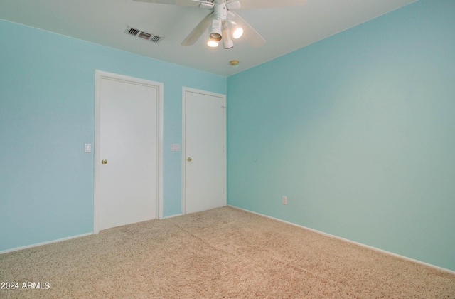 unfurnished bedroom featuring ceiling fan, carpet flooring, and visible vents