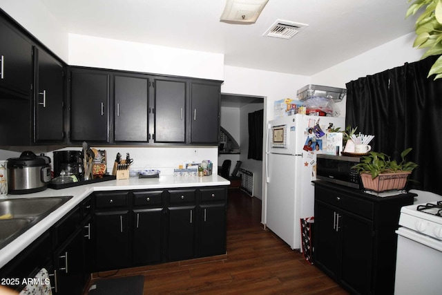 1211 E Fillmore St, Phoenix, AZ 85006 - kitchen with dark cabinetry, white appliances, dark wood-style floors, and light countertops