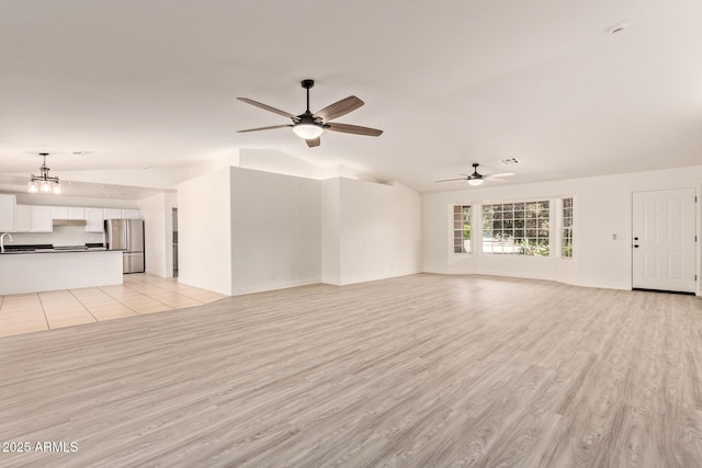 19006 E Karsten Dr, Queen Creek, AZ 85142 - unfurnished living room featuring lofted ceiling, ceiling fan, light wood-style floors, a chandelier, and a sink