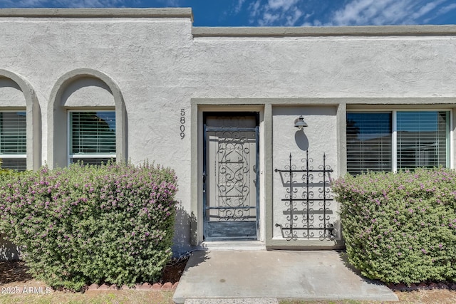doorway to property featuring stucco siding