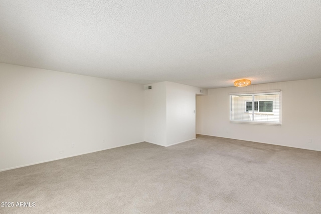 unfurnished room featuring light carpet and a textured ceiling