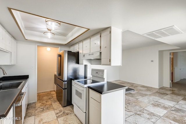 kitchen featuring appliances with stainless steel finishes, under cabinet range hood, a sink, stone tile flooring, and white cabinets