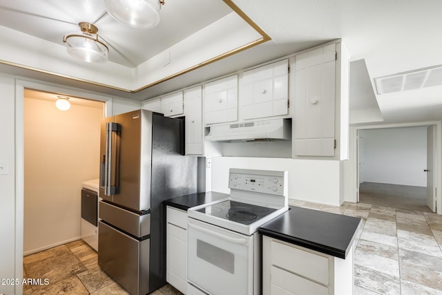 kitchen with white electric range, under cabinet range hood, high quality fridge, stone finish floors, and dark countertops