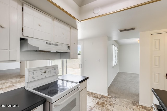 kitchen featuring electric stove, under cabinet range hood, white cabinetry, dark countertops, and light colored carpet