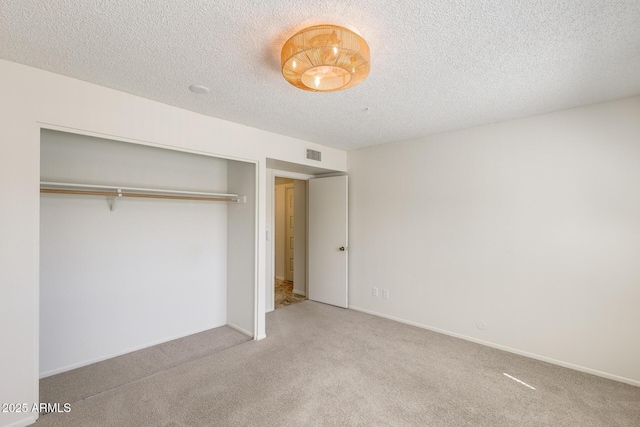 unfurnished bedroom featuring carpet, a closet, and a textured ceiling