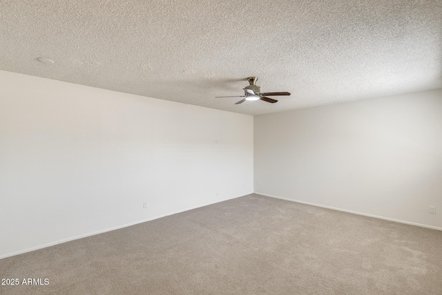 empty room featuring a ceiling fan, carpet floors, and baseboards