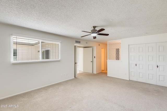 unfurnished bedroom featuring carpet, a closet, ceiling fan, baseboards, and a textured ceiling