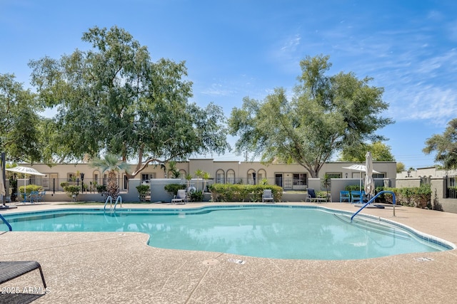 community pool featuring fence and a patio