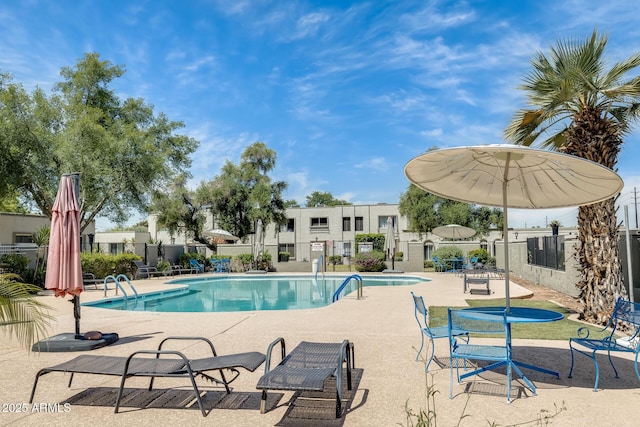 community pool featuring fence and a patio