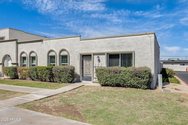 view of front facade with a front yard and stucco siding