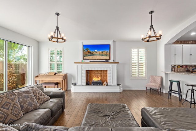 living room featuring a notable chandelier, wood-type flooring, and a fireplace