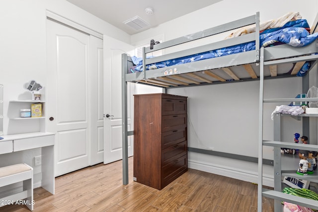 bedroom with hardwood / wood-style flooring and a closet