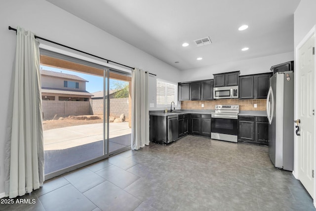14521 W Gelding Dr, Surprise, AZ 85379 - kitchen with light countertops, visible vents, stainless steel appliances, a sink, and backsplash