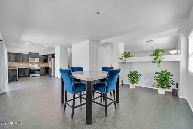 14521 W Gelding Dr, Surprise, AZ 85379 - dining area with arched walkways, baseboards, and recessed lighting