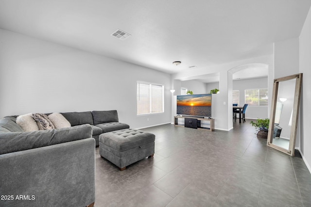 14521 W Gelding Dr, Surprise, AZ 85379 - living room with arched walkways, baseboards, and visible vents