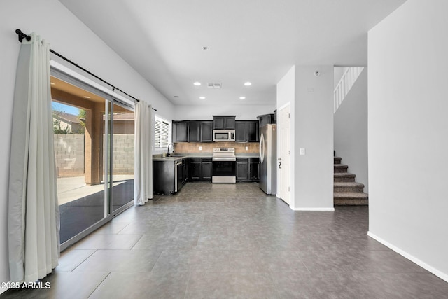 14521 W Gelding Dr, Surprise, AZ 85379 - kitchen with light countertops, tasteful backsplash, stainless steel appliances, visible vents, and dark cabinets