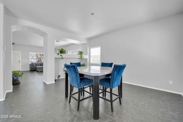 14521 W Gelding Dr, Surprise, AZ 85379 - dining space featuring tile patterned flooring, arched walkways, baseboards, and a wealth of natural light